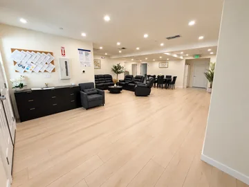 Open common area with leather recliners and light wood-look floors
