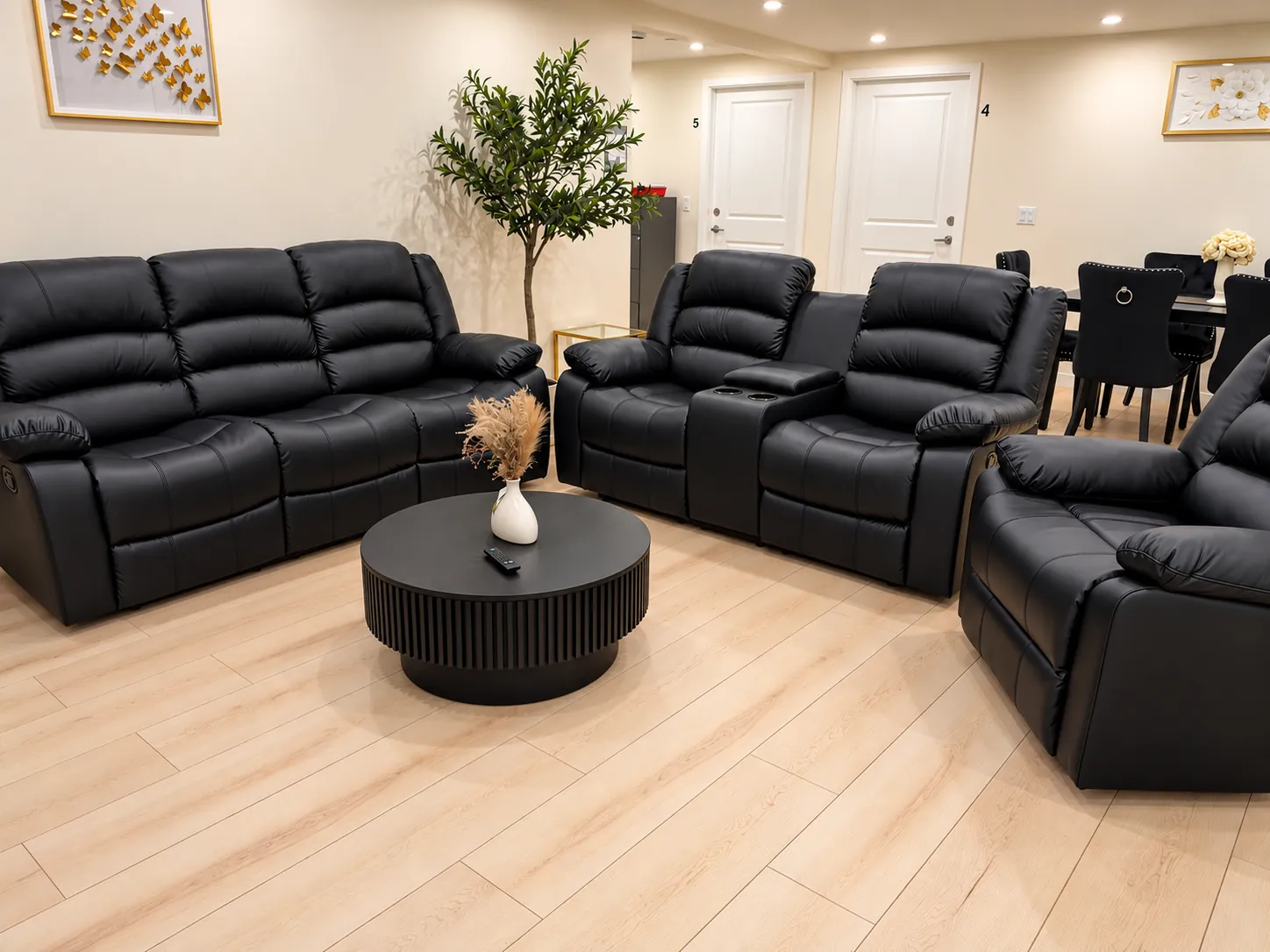 Living room with black leather recliner sofas around a round coffee table