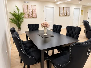 Dining table with tufted chairs and fresh flowers, set for family-style meals